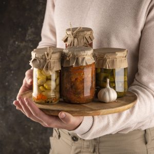 close-up-hand-holding-board-with-jars