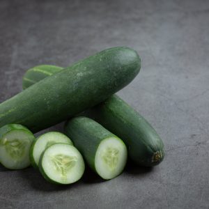 fresh cucumbers sliced on dark background