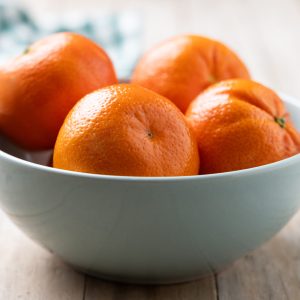 Fresh tangerines in bowl on wooden table