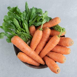 A stack of carrots in the bowl , on the marble background. High quality photo